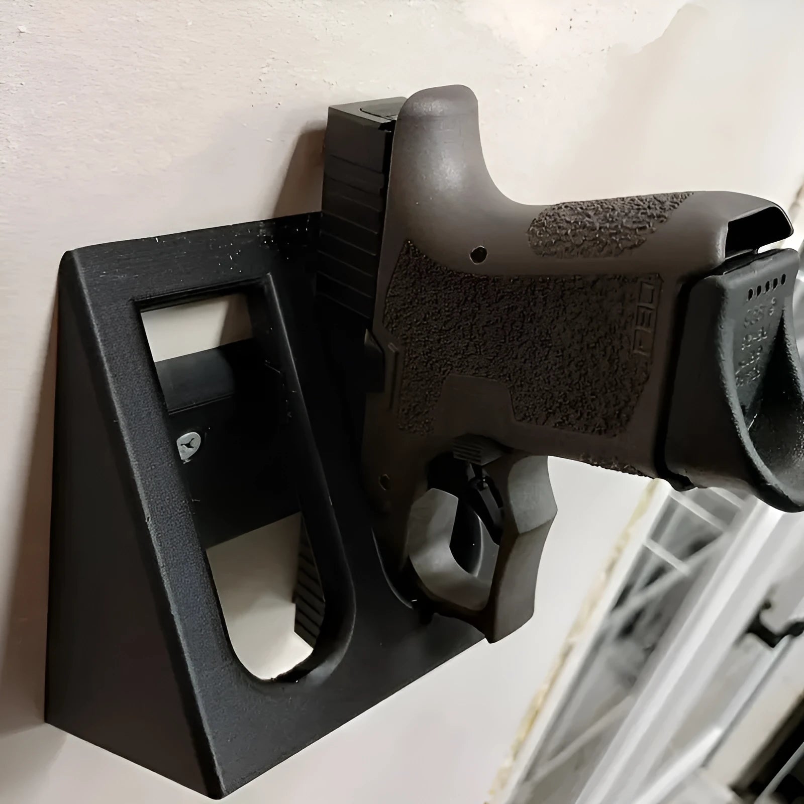 Black plastic pistol display stand for toy guns and cosplay accessories.