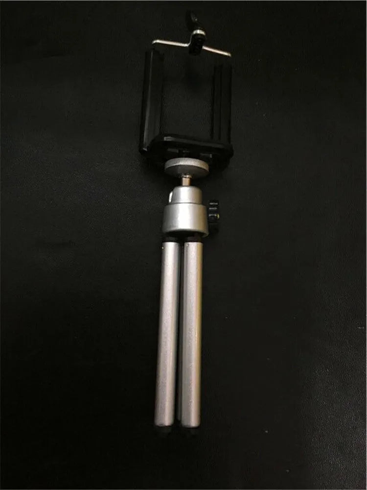 Black adjustable metal desktop phone holder with a two-section bracket holding a smartphone.