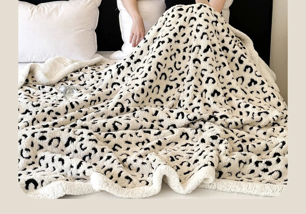 Double-layer jacquard taffeta blanket with leopard print pattern in camel colour on a bed.