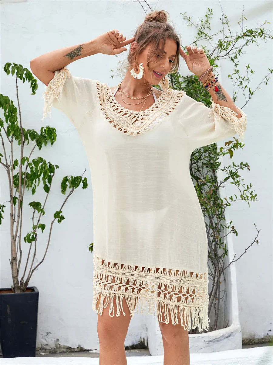 Apricot coloured hand-crocheted women's beach dress on a hanger.