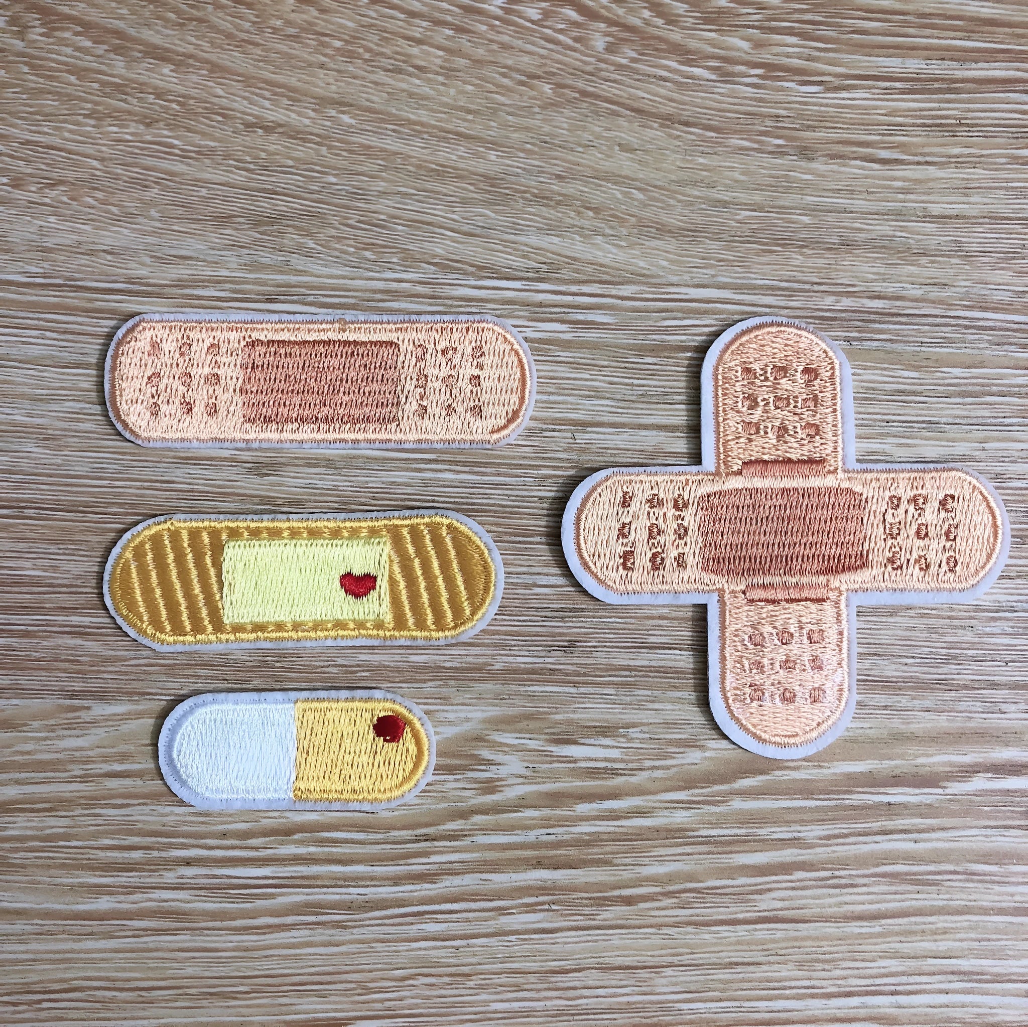 Set of 10 embroidered fabric patch badges with textured thread designs for clothing customisation.