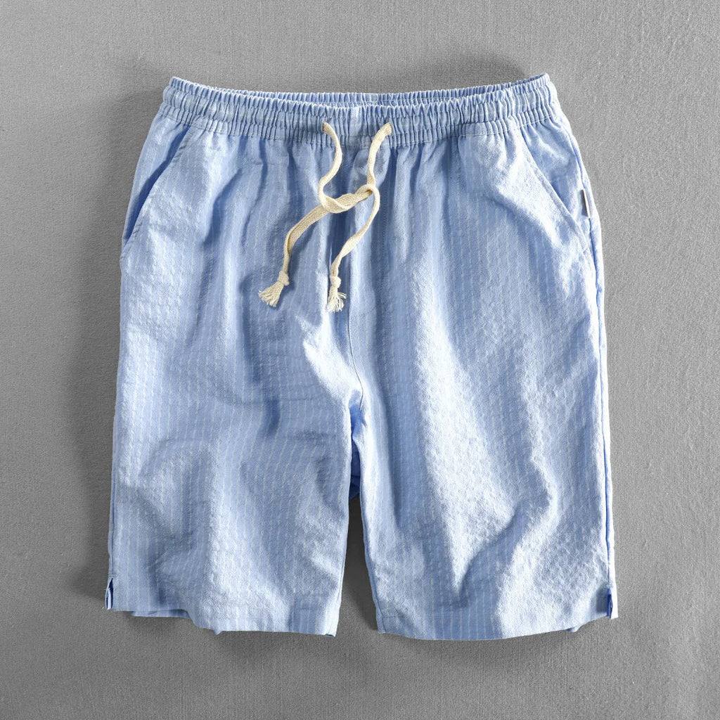 Man wearing black and white striped casual cotton shorts with a loose straight leg fit.