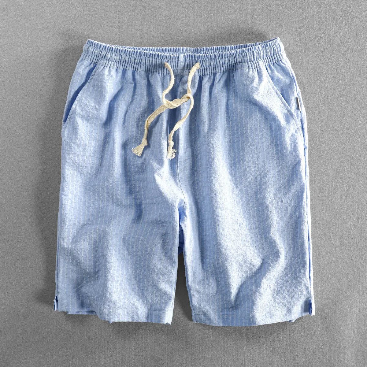 Man wearing black and white striped casual cotton shorts with a loose straight leg fit.