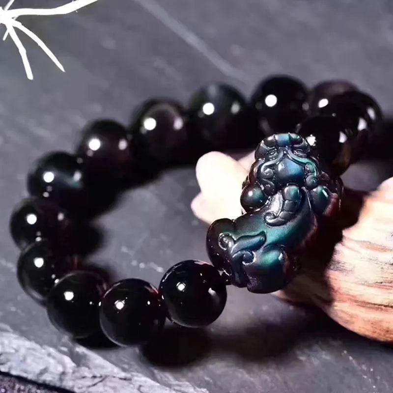 Natural ice colour obsidian crystal bracelet with spherical beads on a wrist.