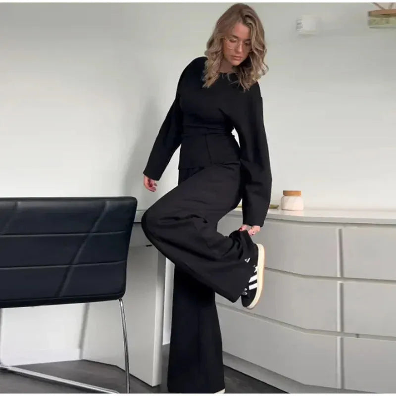 Women's polar fleece suit set with long sleeve O-neck top and wide leg pleated trousers in black.