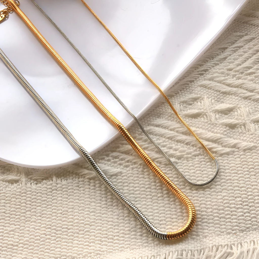 Women's stainless steel snake bone chain necklace with gold finish and geometric line detailing