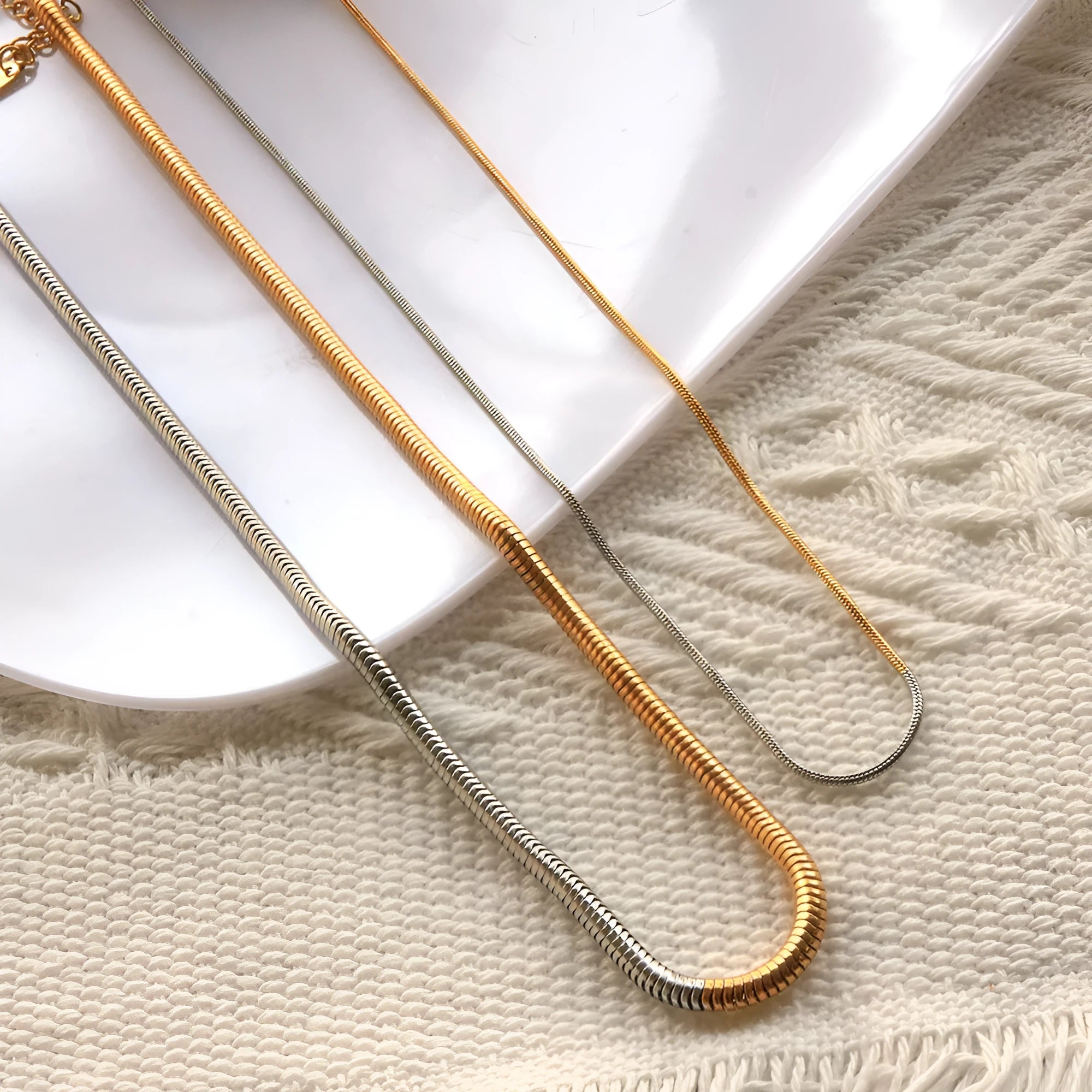 Women's stainless steel snake bone chain necklace with gold finish and geometric line detailing