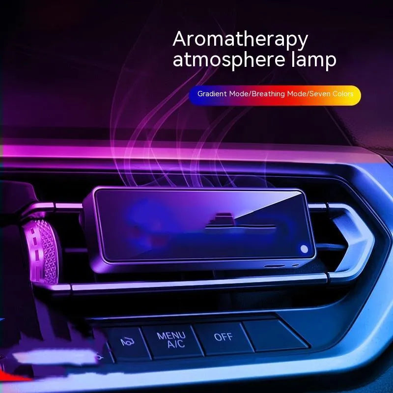 Black automobile aromatherapy LED light attached to a car air vent with a fragrance stick.