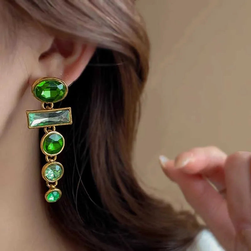 Close-up of green gradient geometric alloy earrings with long tassels and sparkling inlaid zircons.