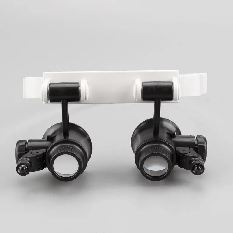 White head mounted magnifying glass with LED light, shown folded and unfolded