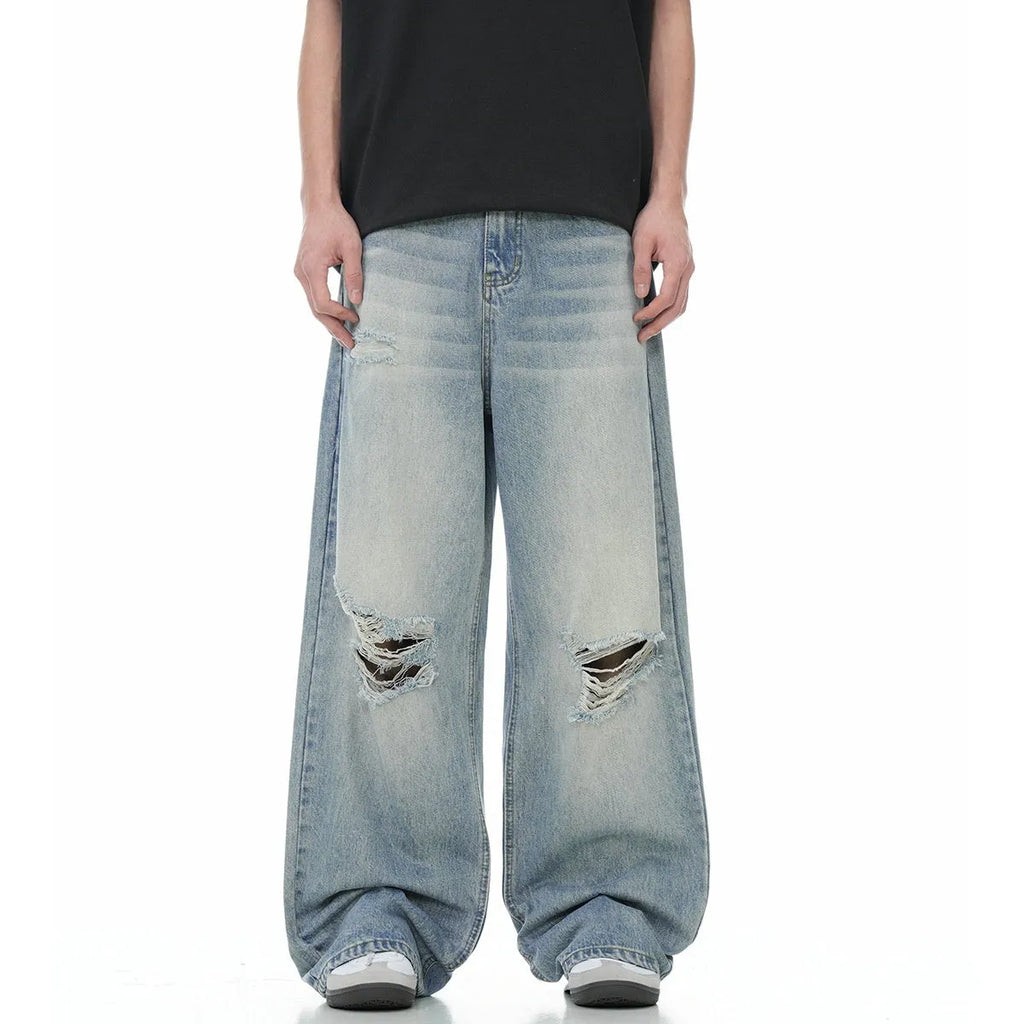 Men's blue straight-leg jeans with ripped details on the legs, showing a zipper fly.