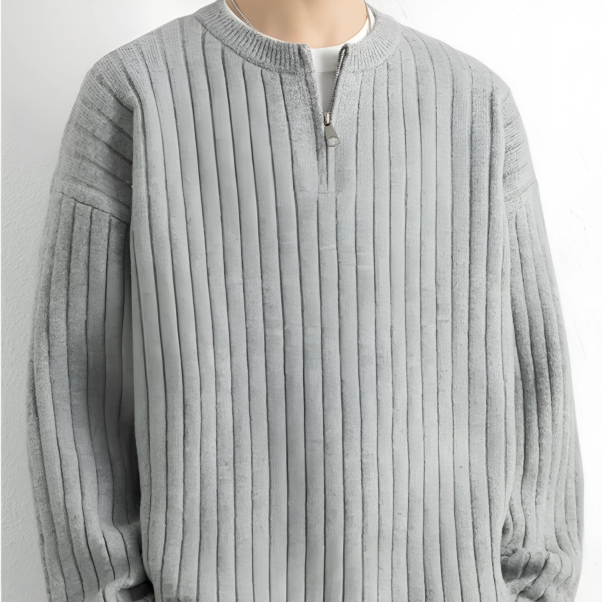 Man wearing a grey textured knit half zip sweater with a loose fit and long sleeves.