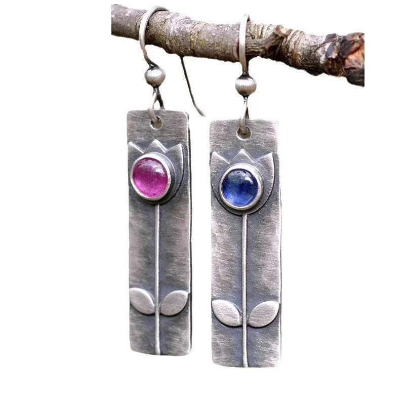 A pair of antique finish red sapphire geometric drop earrings with an elliptical design in a retro style