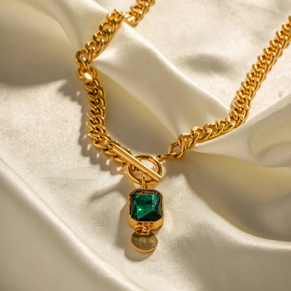 Gold electroplated geometric round pendant necklace with Cuban link chain and emerald zircon detail