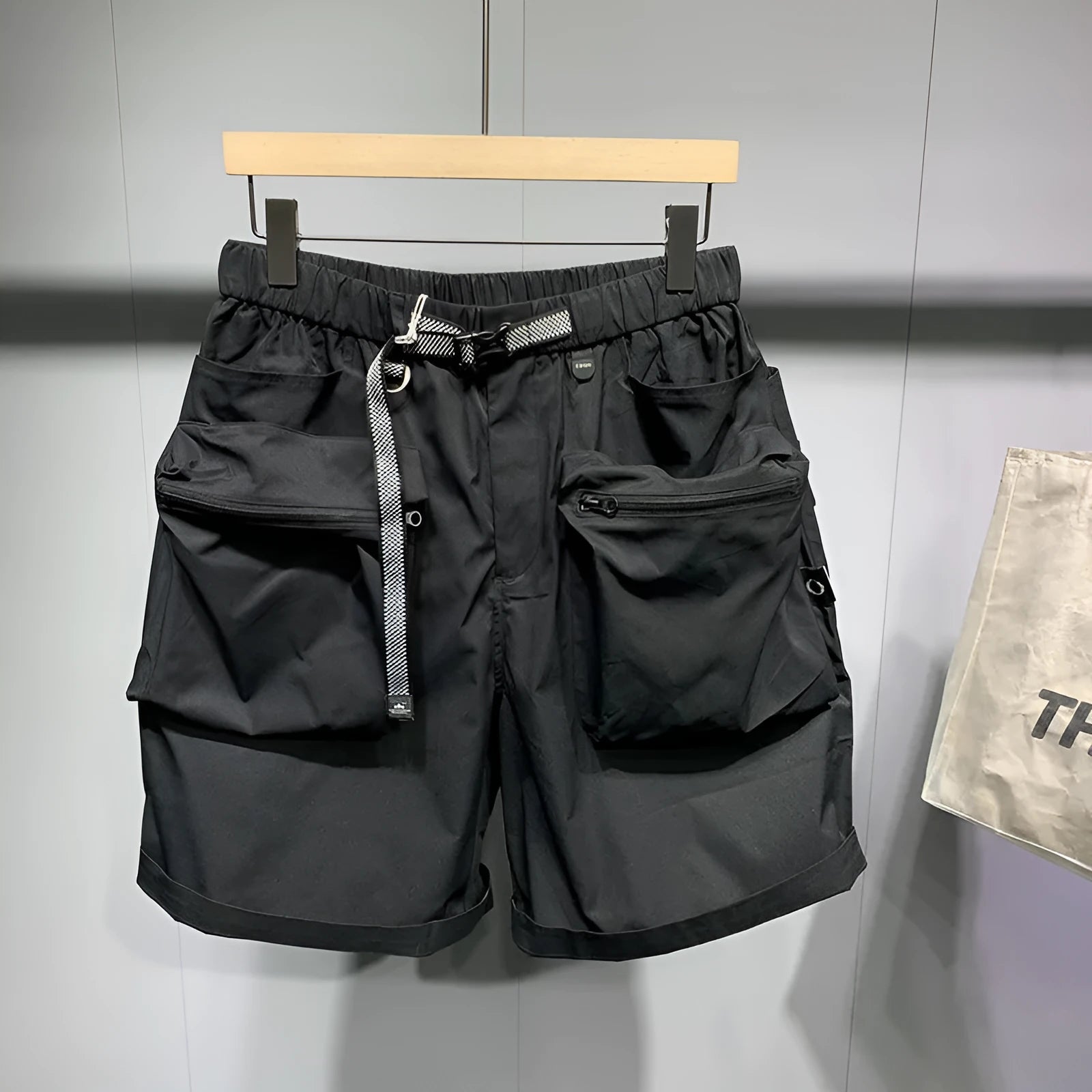 Men's loose fit black casual shorts with large side pockets and an elasticated waistband.