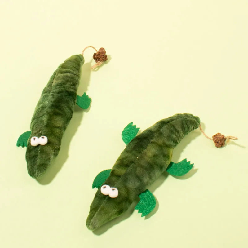 Green plush alligator catnip toy with plant-based materials and peppermint scent for feline oral cleansing