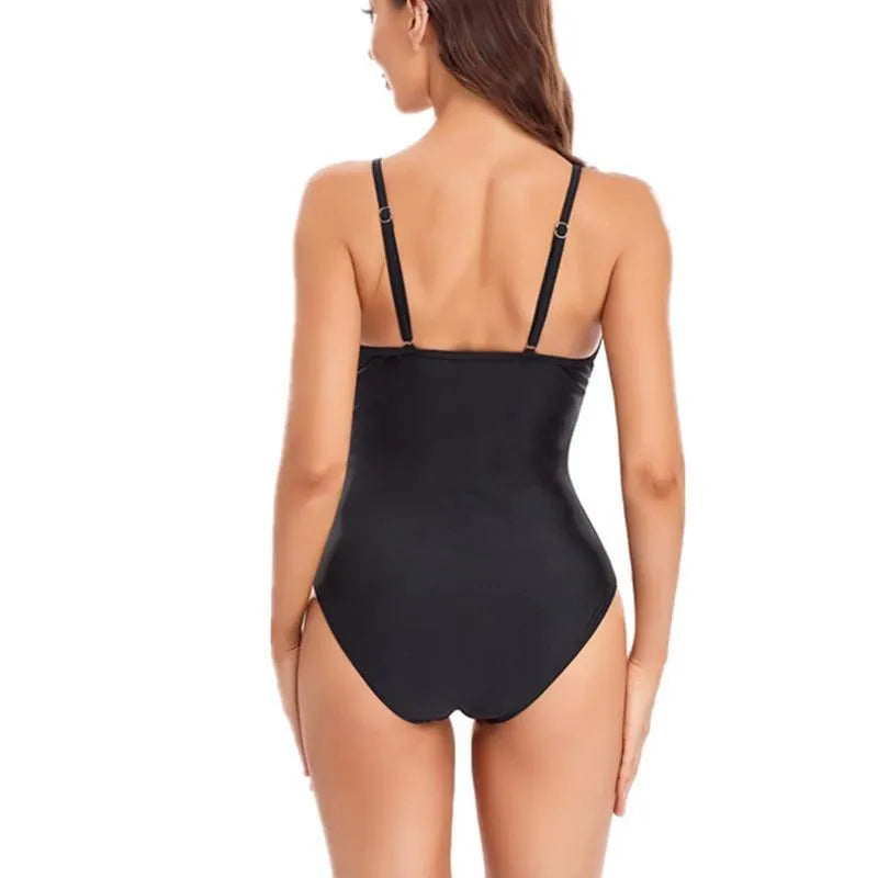 A black one-piece swimsuit with mesh panelling and a backless design on a mannequin.
