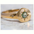 Golden oval asterism star ring with zircon stones and an adjustable opening.