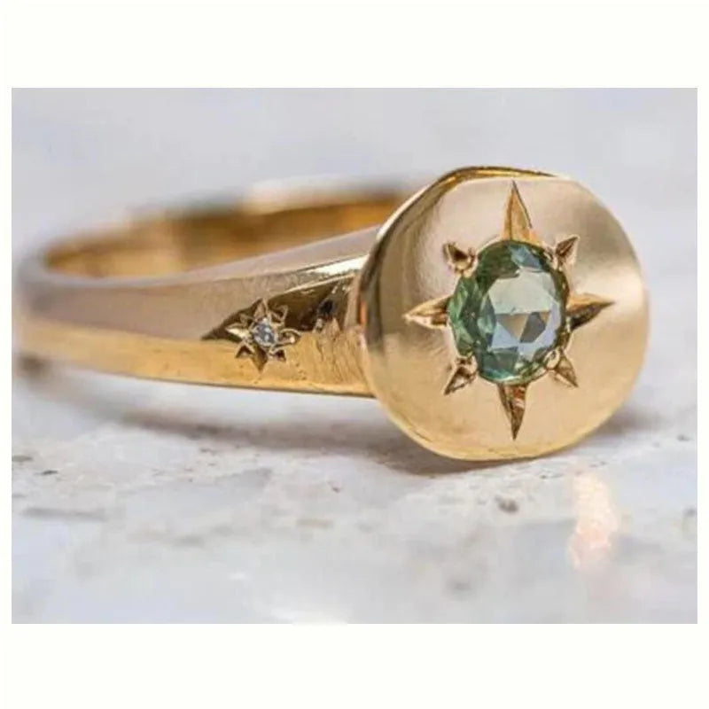 Golden oval asterism star ring with zircon stones and an adjustable opening.