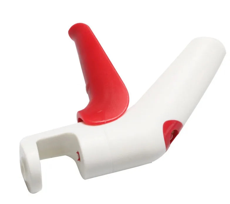 Stainless steel cherry kernel remover pitter tool on a kitchen worktop