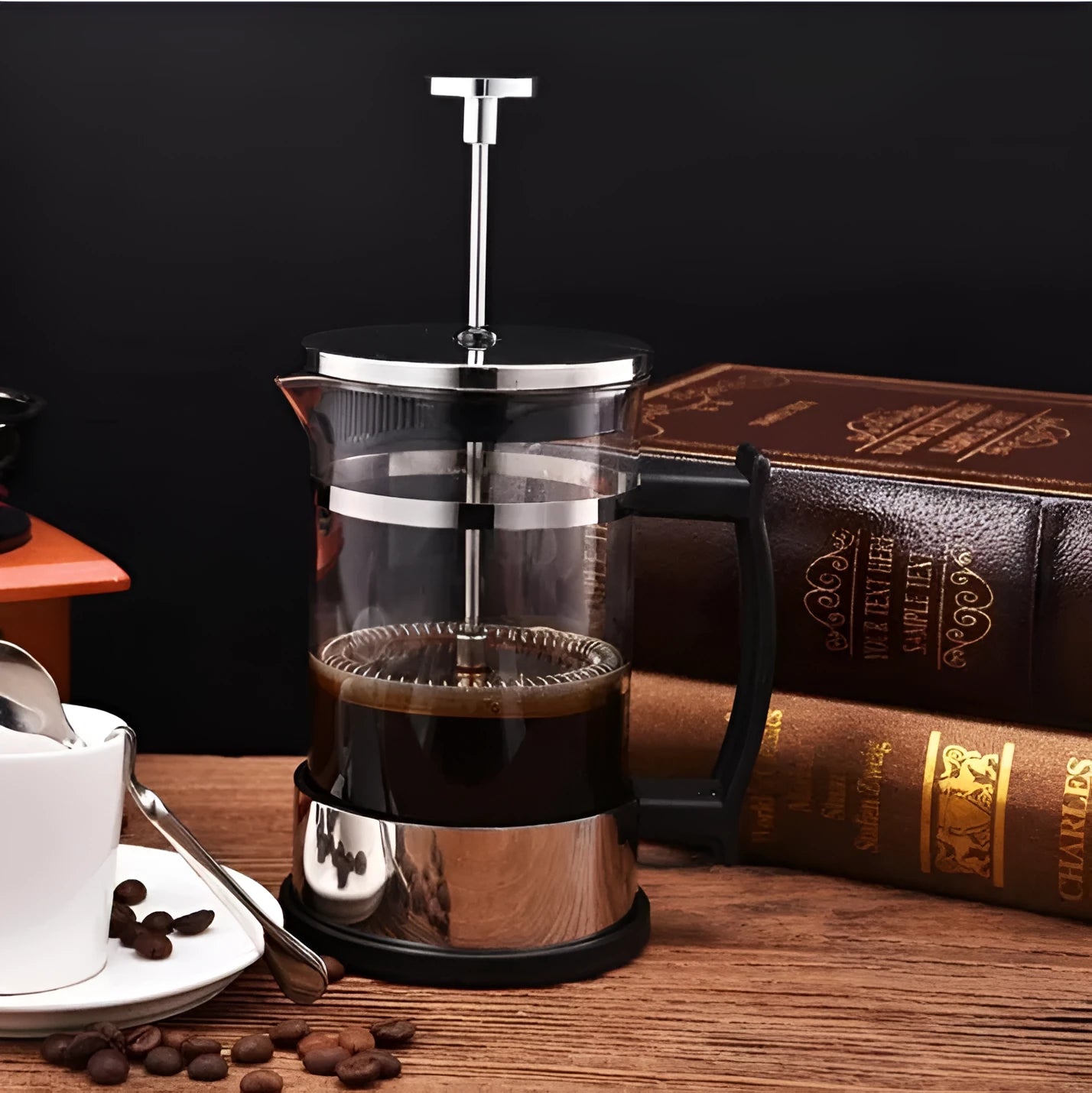 Compact stovetop moka pot coffee maker with glass top and stainless steel base.