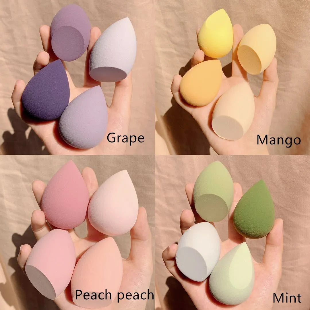 Set of four coloured makeup egg sponges (grape, mango, mint, peach) shown next to a 6cm cube for scale.
