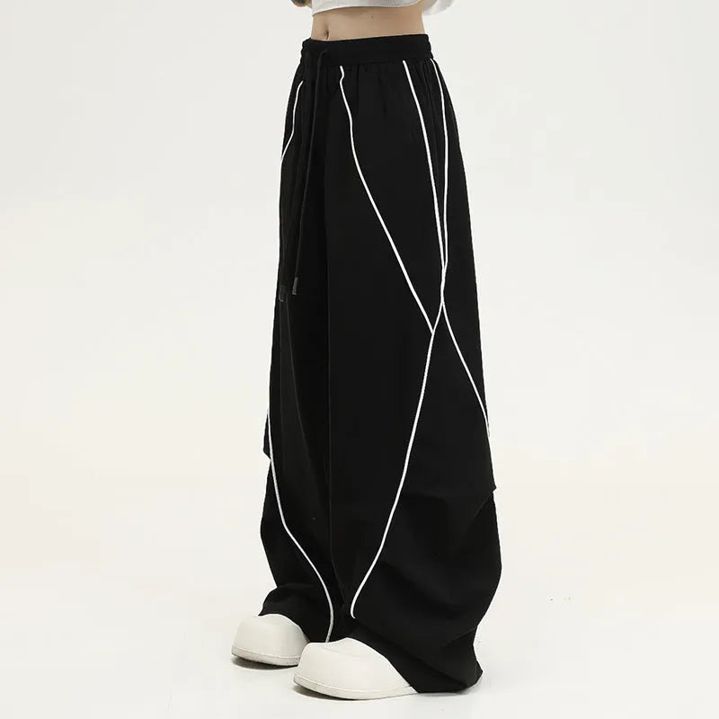 Black striped pleated hip hop trousers with wide-leg design shown flat