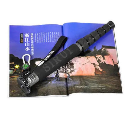 Black carbon fibre telescopic camera monopod fully extended next to a DSLR camera.