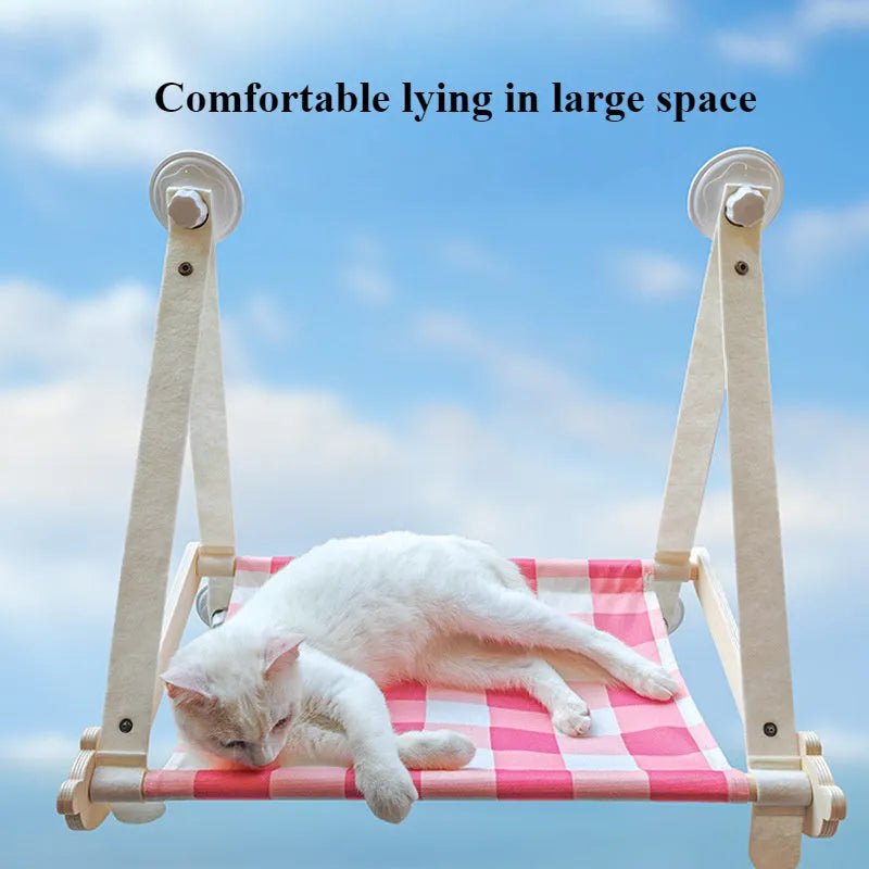 Foldable wooden cat window hammock with suction cups attached to a glass pane.