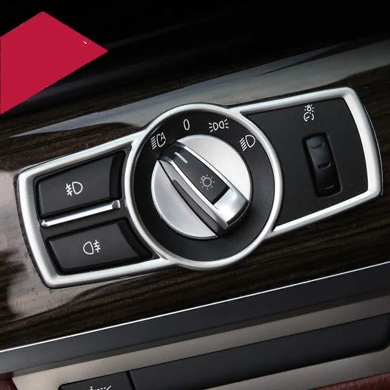 Silver ABS plastic decorative strip sticker for BMW headlight switch frame interior modification.