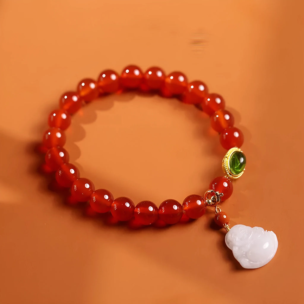 Handmade red agate and amber bracelet with geometric beads and a gold Maitreya Buddha charm.