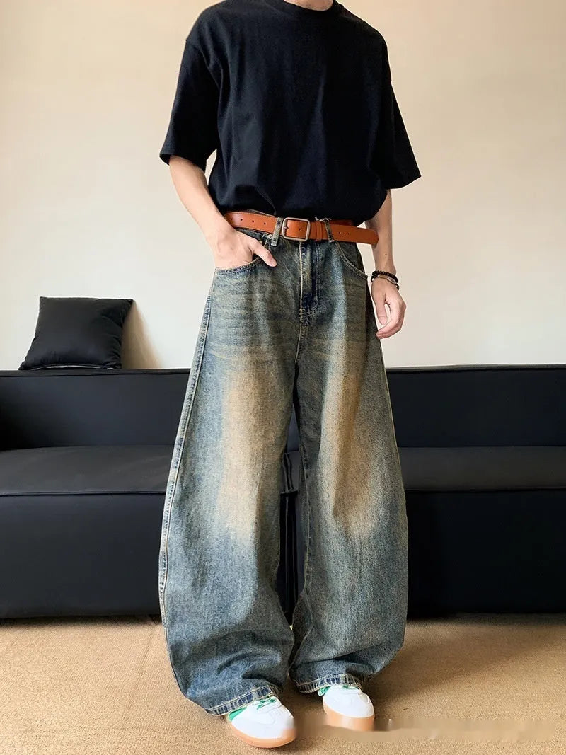 Man wearing retro blue distressed wide-leg denim jeans with a slimming fit and mid waist design.