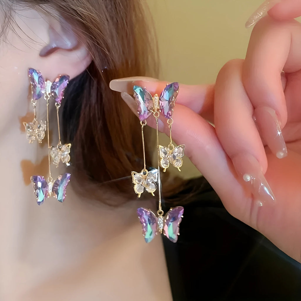 Blue purple butterfly earrings with crystal flowers and tassel details on silver needle posts
