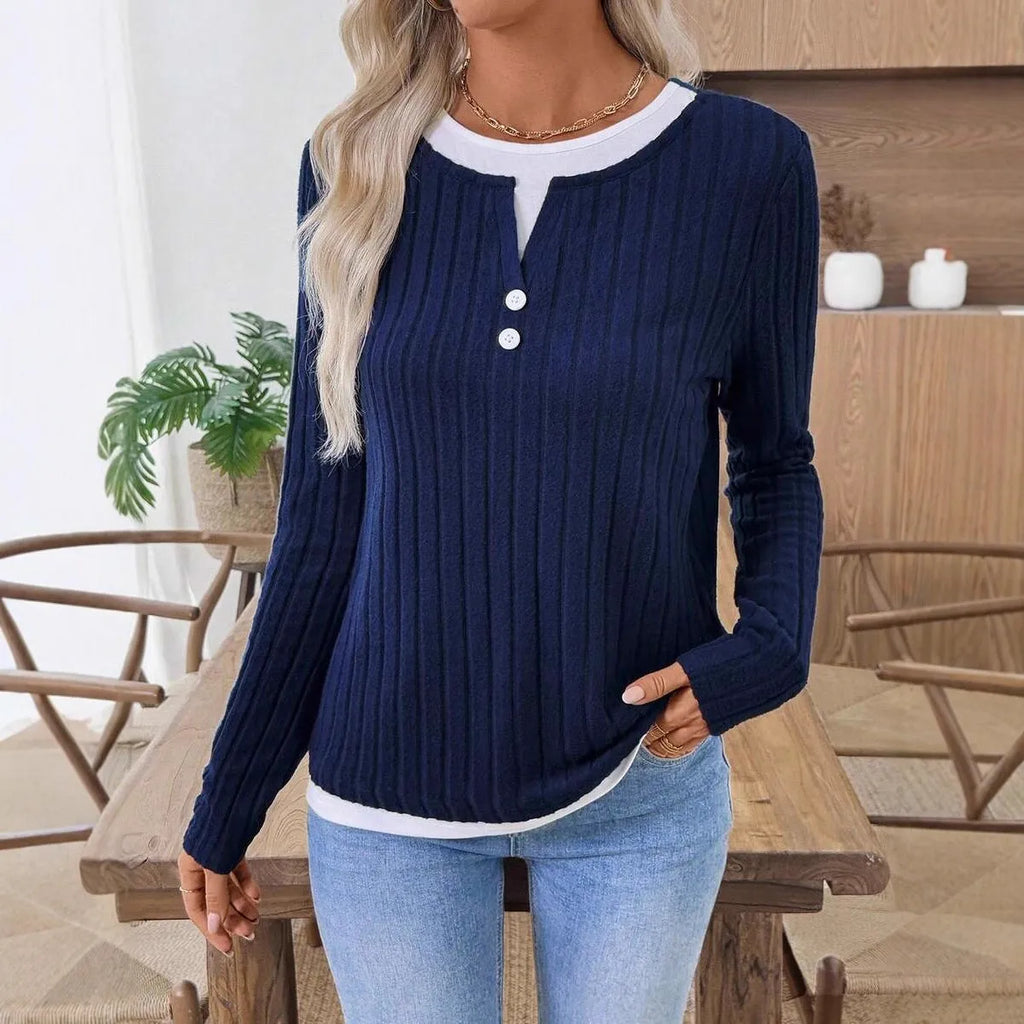 Women's black fake two-piece pullover sweater with button front and round neck on a model.