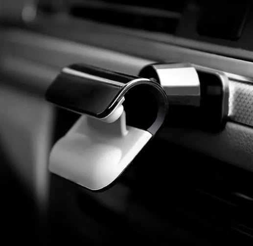 Black universal car phone holder with 360-degree rotating ball joint on a car dashboard.