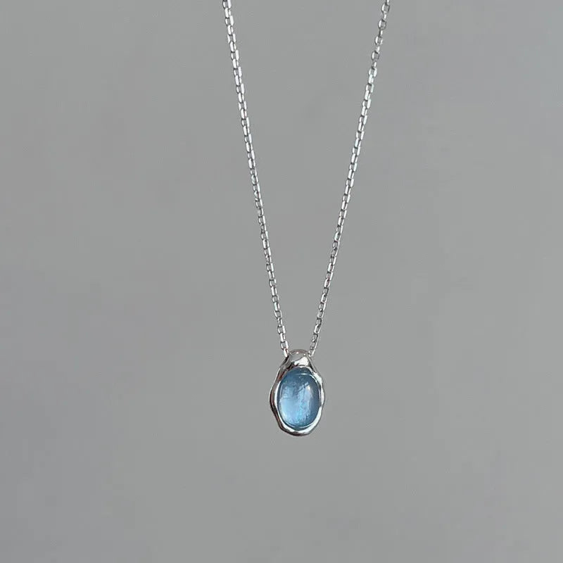 Navy blue geometric water drop necklace on adjustable cross chain, platinum-colour finish