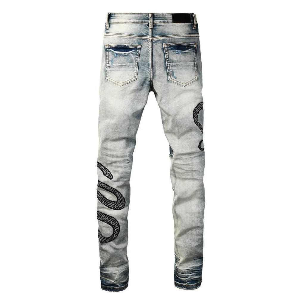 Close-up of vintage blue wash distressed skinny jeans with a tapered leg and button fly.