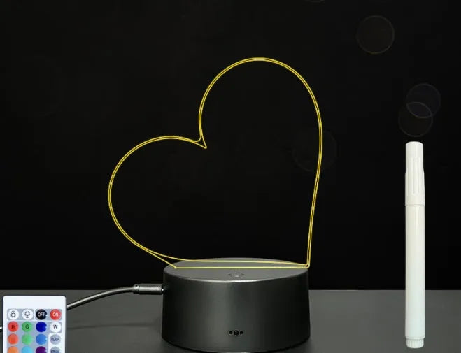 3D acrylic message board LED lamp lit up on a desk with remote control and marker pen.