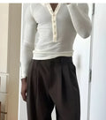 Men's cream apricot ribbed long-sleeve henley top with buttoned placket on a hanger.