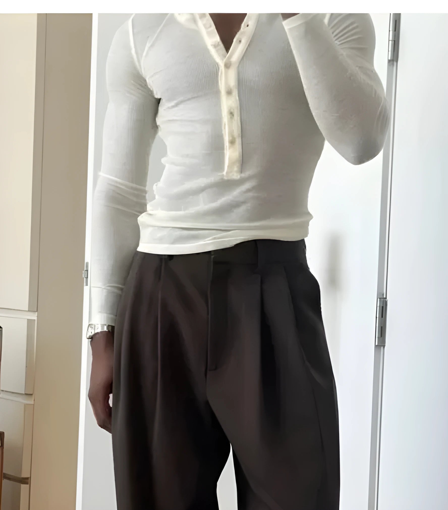 Men's cream apricot ribbed long-sleeve henley top with buttoned placket on a hanger.