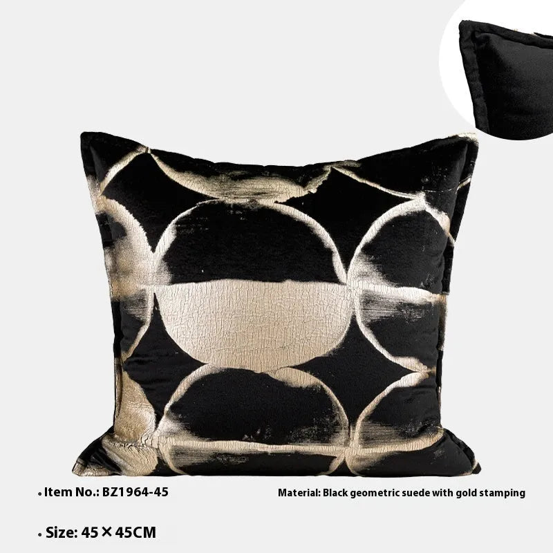 Abstract pattern black and gold decorative cushion pillow with removable cover on a grey sofa.