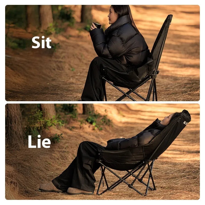 Night Black Oxford cloth folding moon chair in a reclined position on grass.