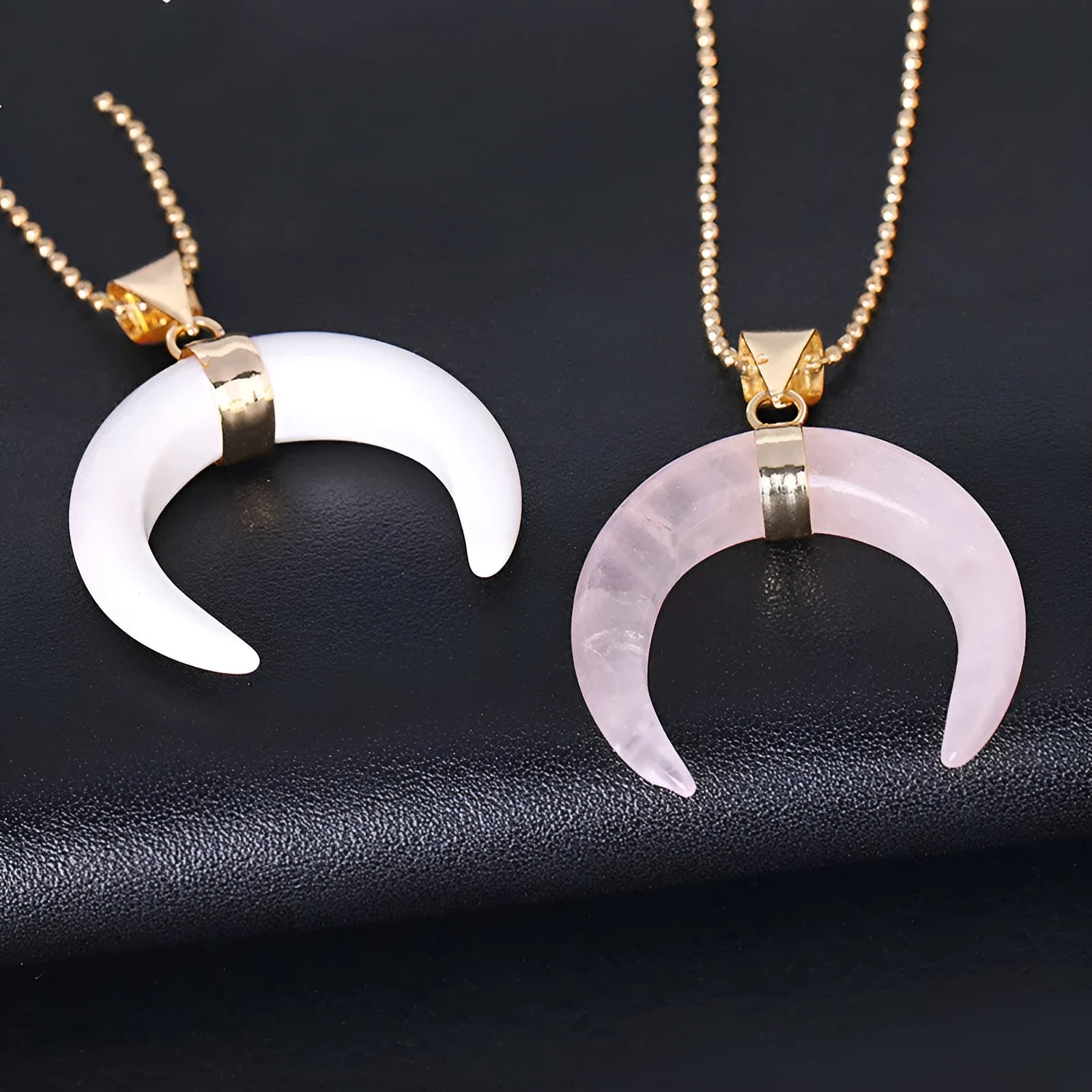 A pink semi-precious stone moon pendant on a copper-coloured chain, laid flat.