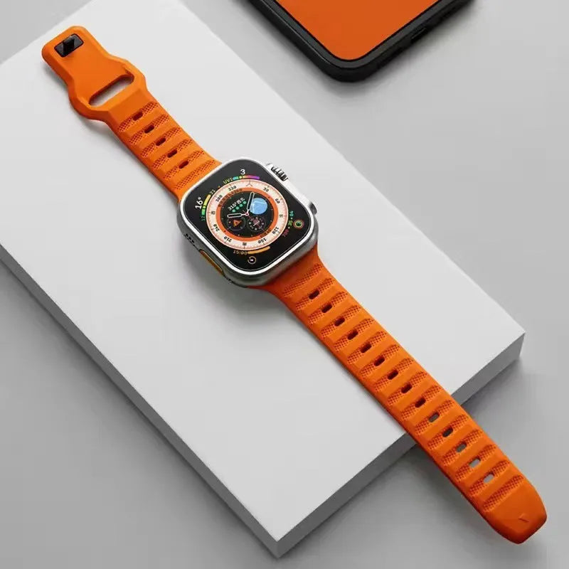 Black fluoro rubber Apple Watch band with T-buckle on a wrist, showing attachment to a watch case.