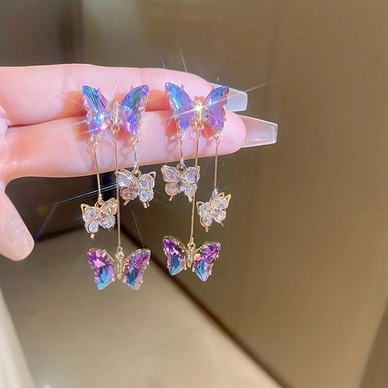 Blue purple butterfly earrings with crystal flowers and tassel details on silver needle posts