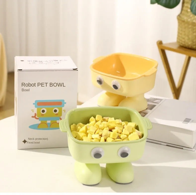 Green elevated cat bowl with 15-degree tilt, detachable inner dish, and cartoon robot design on a table.