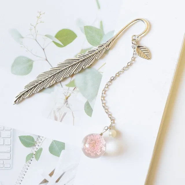 Dried flower specimen bookmark with alloy metal pendant in blue starry sky design.