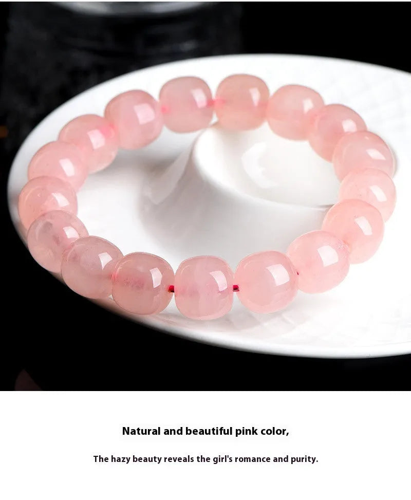 Pink natural crystal bracelet with barrel-shaped beads measuring 8 to 10 mm.