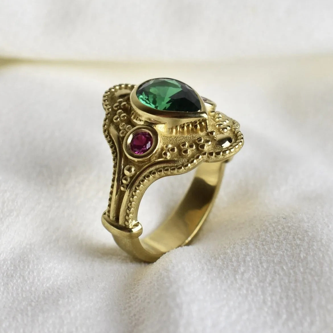 Geometric golden women's fashion ring on a grey background, showing its electroplated alloy construction.