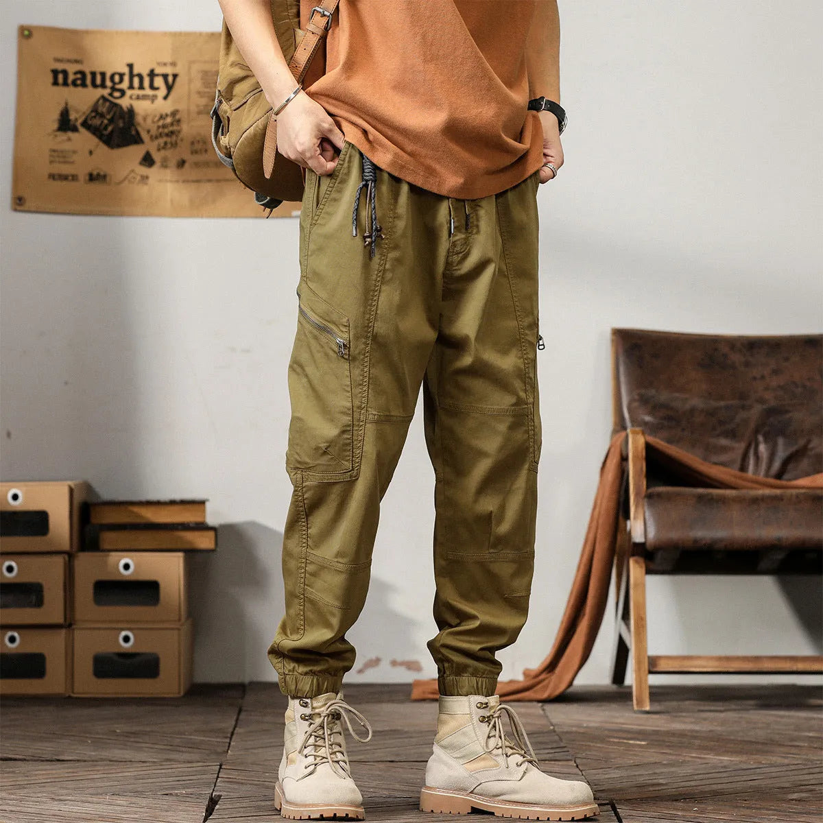Men's loose cotton harem pants in khaki with a tapered ankle opening and zip fly.